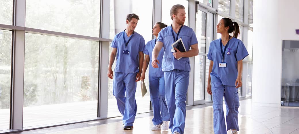 Four nurses walking down a hospital hallway